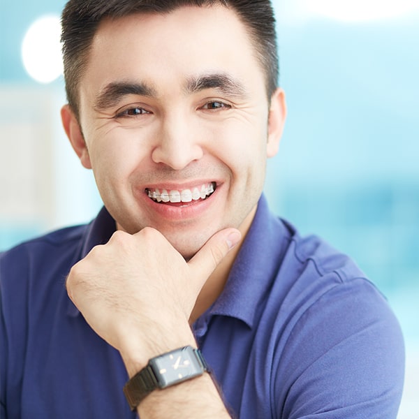 A middle aged man smiling with transparent braces